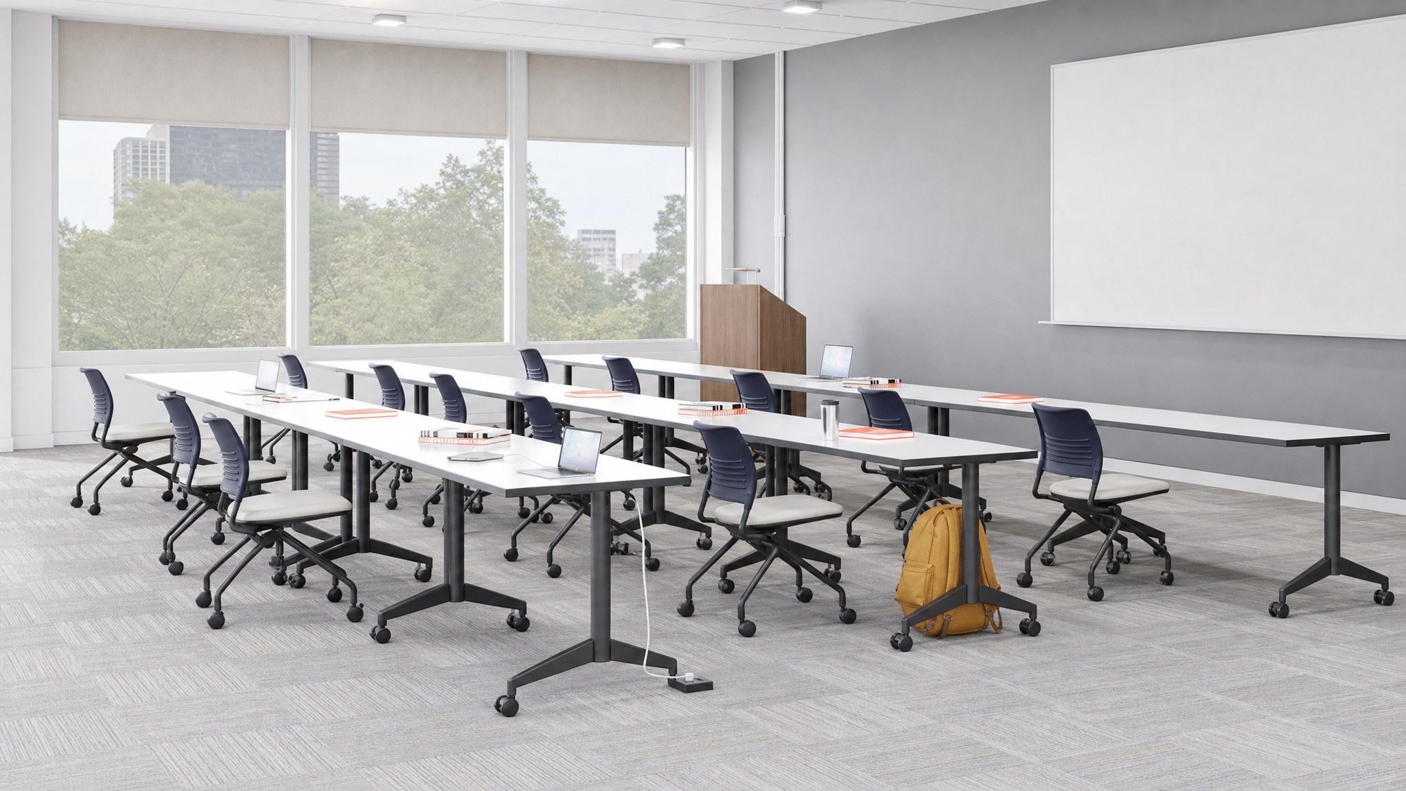 Rectangular floor cable raceway on carpet beneath tables with laptops in a conference room.