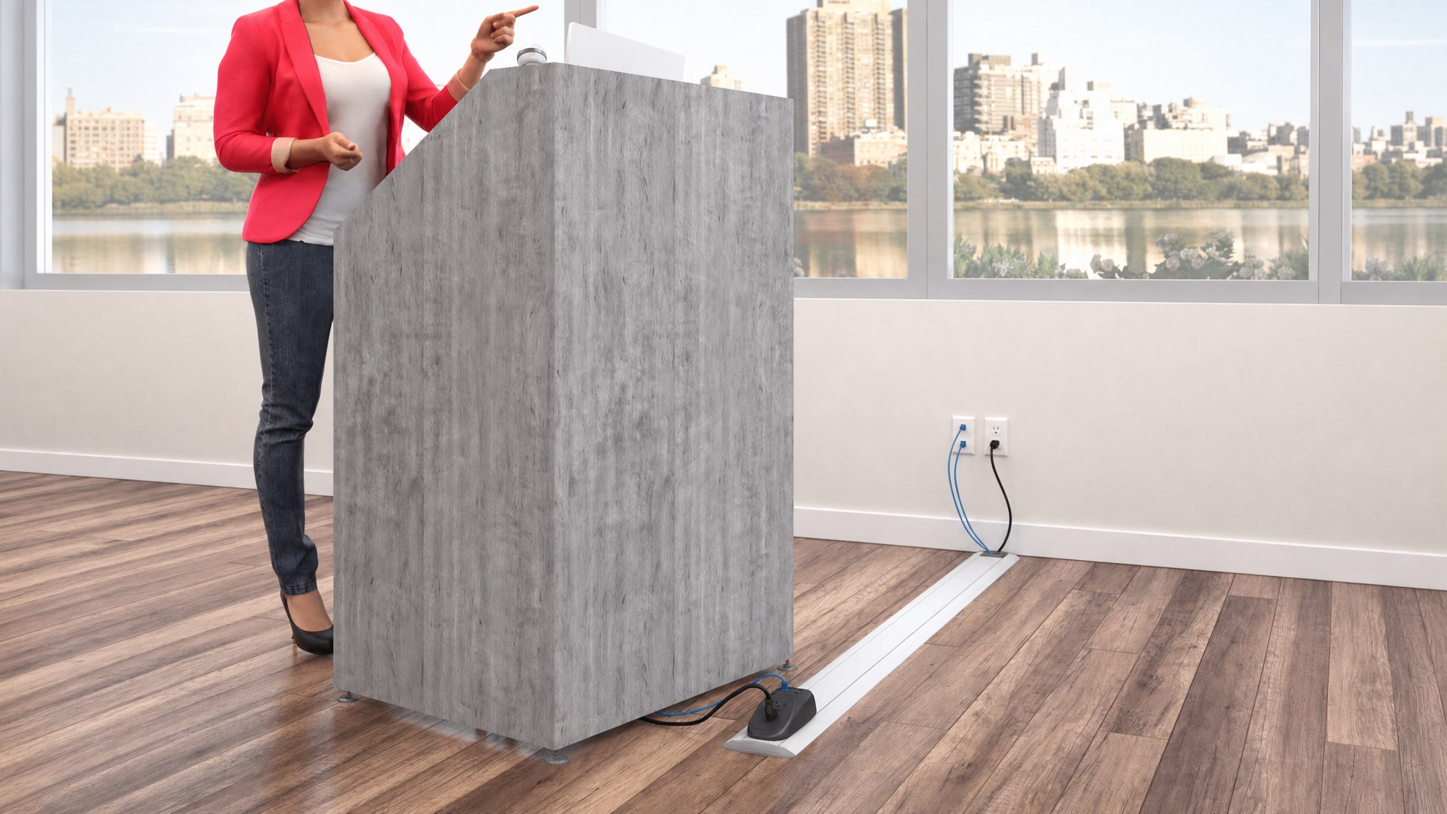 Floor cable raceway running from wall outlet to podium on wood floor.