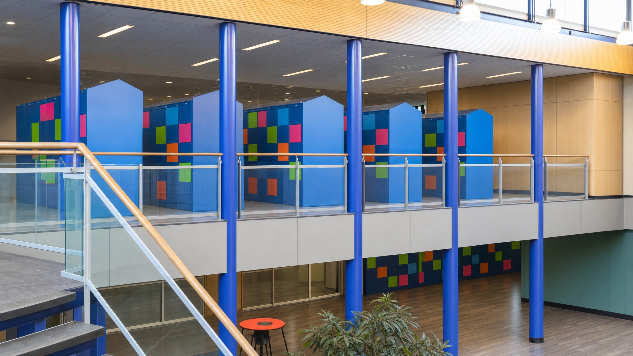 Blue locker walls with colorful square doors in a modern open hallway.