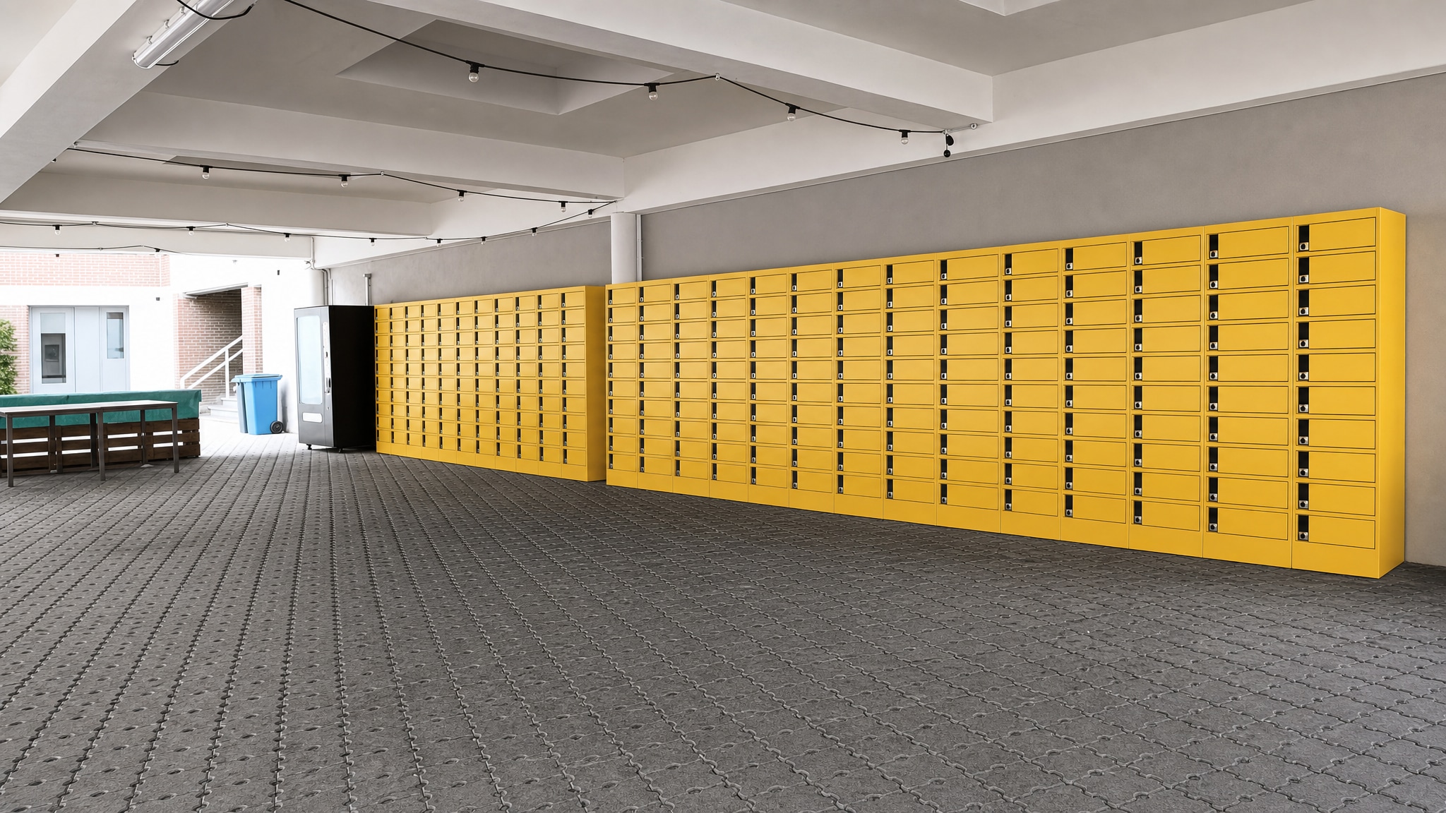 Long wall of yellow lockers in a covered outdoor area with benches and a vending machine.
